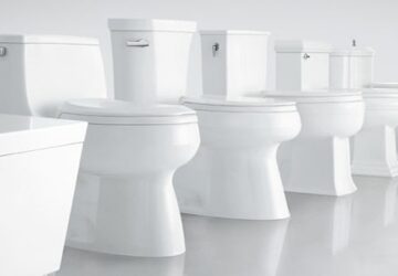 Five white porcelin toilets lined up next to each other